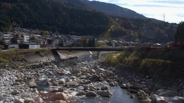 Traffic crosses shallow rocky Kiso River: Nagiso Japan mountain valley