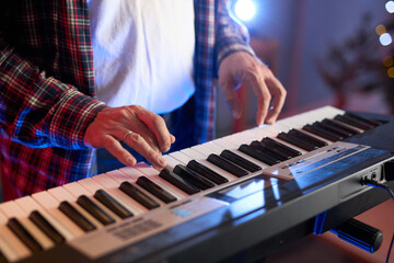 Obraz premium A close-up of hands playing a digital keyboard synthesizer