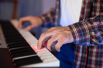 Obraz premium A close-up of hands playing a digital keyboard synthesizer