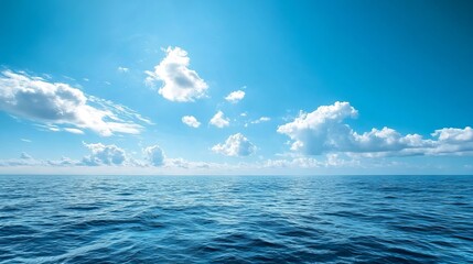 Obraz premium A serene ocean landscape with a bright blue sky and fluffy white clouds