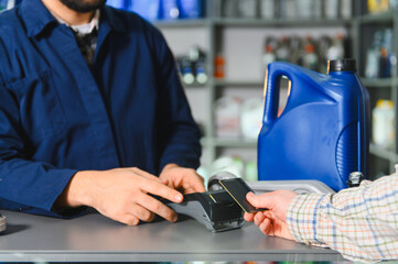 Mechanic processing credit card payment for auto service