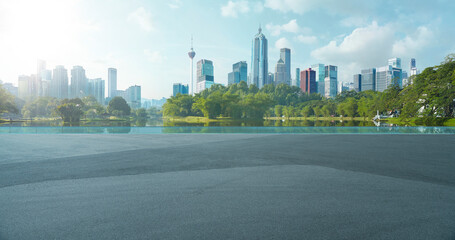 Fototapeta premium Kuala lumpur city skyline and park lake view with empty road