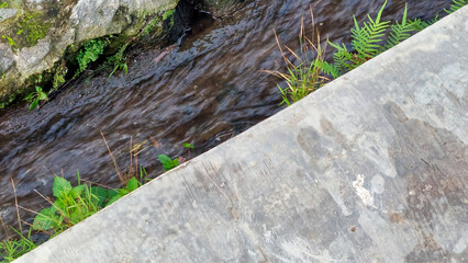 Clear Water Flowing Through a Concrete Drainage Ditch