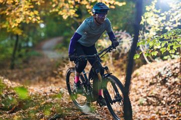 Mountain Biker Navigates Autumn Forest Trail in Gear, Helmet, and Dynamic Trail Ride