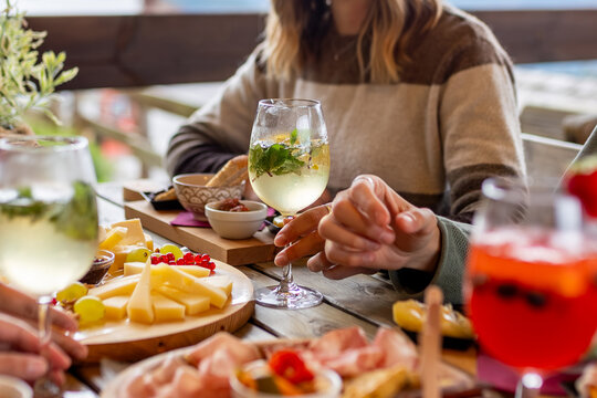 Ugo Hugo Mint prosecco cocktail aperitivo, outdoor table spread, tapas, charcuterie, cheese, orange spritz, woman, lifestyle dining scene