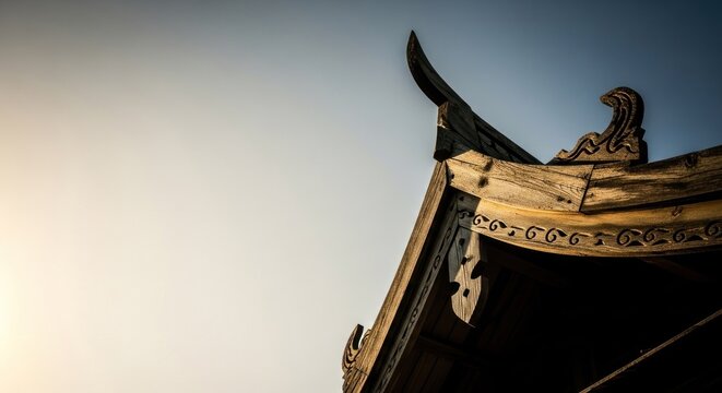 Angled shot of a weathered, ornate wooden roof against a gradient sky