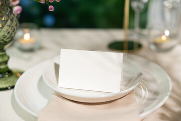 Mockup white blank space card, for Name place, Folded, greeting, invitation on wedding table setting background. with clipping path © negoworks