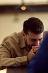 Obraz premium Contemplative Man With Hands Clasped In Diner, Quiet Moment Of Reflection