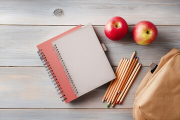 Flat lay back to school composition with notebooks, pencils, backpack and apples on wooden desk