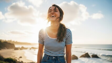 Fototapeta premium joyful woman laughing on a cliff overlooking the ocean at sunset with golden hour light