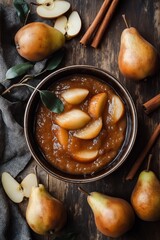 Overhead view of slow-cooked pear butter served in a bowl, fresh pears and cinnamon sticks on the side, rustic kitchen table