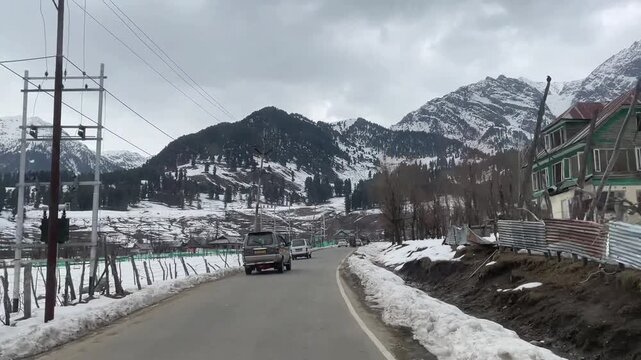 Scenic road and pathway leading to Aru Valley surrounded by lush meadows, pine forests, rivers, and Himalayan mountain landscapes near Pahalgam, Kashmir.
