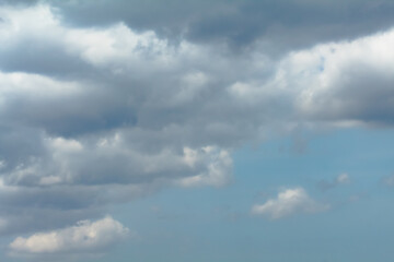 Fototapeta premium The sky is cloudy and the sun is not visible. The clouds are white and grey. The sky is blue and the clouds are scattered.