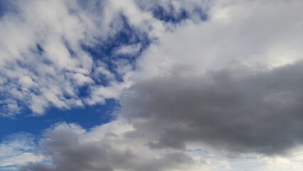 Obraz premium Dramatic Dramatic Sky with White and Grey Cumulus Clouds on a Deep Blue Background