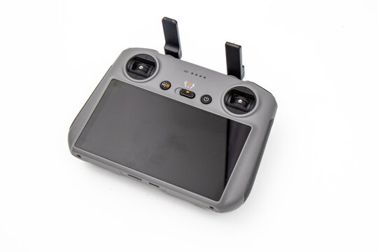 Professional drone remote controller with screen and damaged gimbal camera unit after crash, quadcopter repair and aviation insurance concept, isolated on white background macro shot.