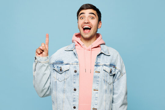 Young smart proactive man he wears pink hoody denim casual clothes holding index finger up with great new idea isolated on plain pastel light blue cyan background studio portrait. Lifestyle concept.