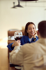 Obraz premium Asian Woman Enjoying Wine On Date At Modern Diner, Smiling, Toasting With Friend