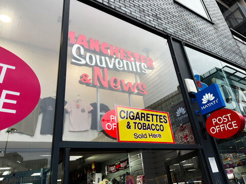 Manchester souvenirs and news shopfront in the city centre with post office sign and cigarettes