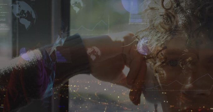 Animation of infographic interface and globe over caucasian listening music over headphones at home