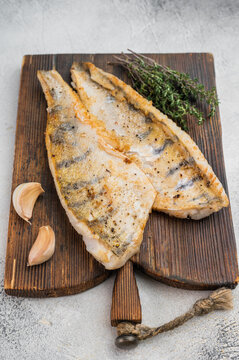 Lean fried white fish with fresh herbs and natural seasoning, high protein healthy food concept.