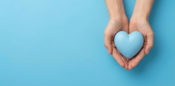 Healthcare and medical insurance concept with hands holding blue heart shape on isolated blue background for charity