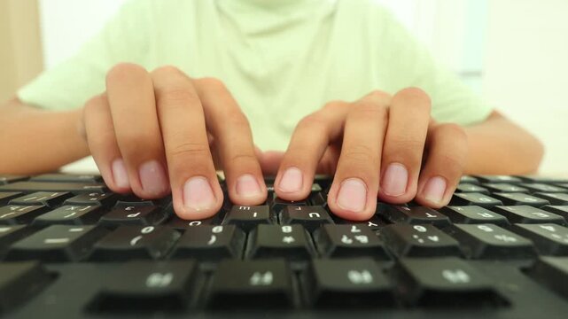 Ultra close view of fingers typing on a black keyboard, nails clean, motion fluid, light green shirt blurred behind, emphasizing digital fluency, focus, and the tactile precision of modern work