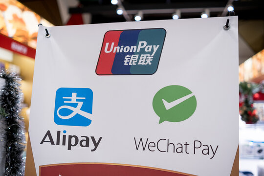 Moscow, Russia - January 25, 2026: UnionPay, Alipay, and WeChat Pay logos displayed on promotional sign in shopping area, digital payment options