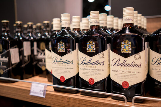 Moscow, Russia - January 25, 2026: Ballantine's Finest blended Scotch whisky bottles displayed on wooden shelf in liquor store with various brands