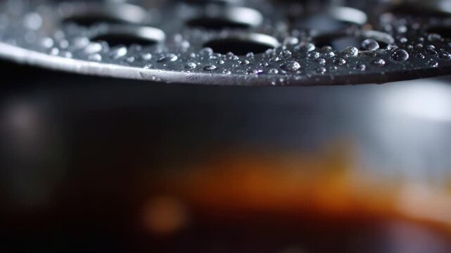 Close-Up Photography of Dripping Water Droplets from a Metal Surface Highlighting the Beauty of Fluid Dynamics and Refraction in an Indistinct Background