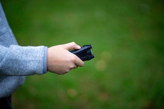 Compact stun gun in the hands of a child.An electric device for scaring away dogs.Current protection.
