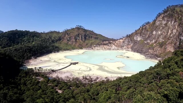 Scenic view of Kawah Putih volcanic crater lake in Ciwidey West Java, Indonesia on a sunny day with a blue sky and no people