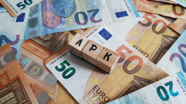 APK acronym made of wooden letter cubes on pile of Euro banknotes. Altersvorsorgekonto (Retirement Savings Account)
