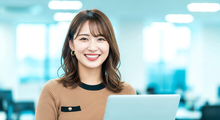 PCを使いオフィスで笑顔を見せる女性社員