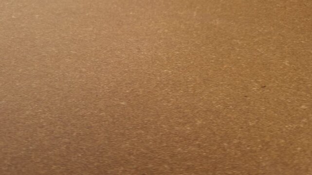 Warm brown leatherboard sheet surface with fine pressed fiber texture.