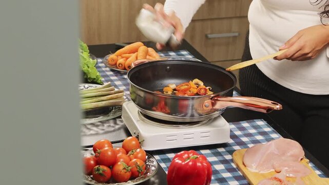 A woman uses a wooden spoon to measure and stir homemade sauce, capturing the warmth of home cooking and traditional culinary preparation in a rustic kitchen setting.