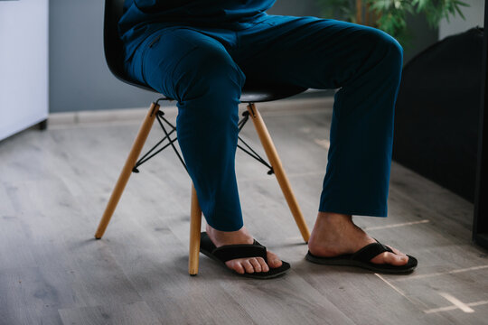 Healthcare professional relaxing in scrubs and flip-flops