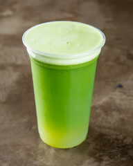 Green vegetable and fruit juice in a plastic cup