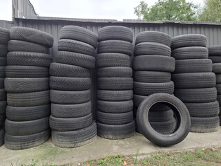 Old car tires are stacked on top of each other near a tire shop © Harmony Video Pro