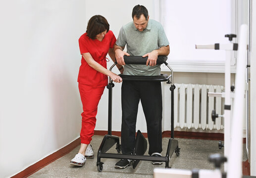 Physical therapy rehabilitation concept. Physiotherapist help patient use walking frame on recovery session. Gait training with walkers, mobility support, balance exercise, orthopedic rehabilitation