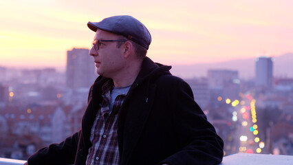 Handsome man side portrait on the city building rooftop in the evening