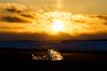 Jewelry ice glowing in sunset light on Otsu Coast, Hokkaido, Japan © harumachi