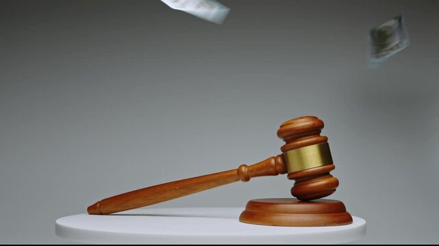 Court gavel rests on a white table in a simple setup for legal proceedings in a courtroom setting