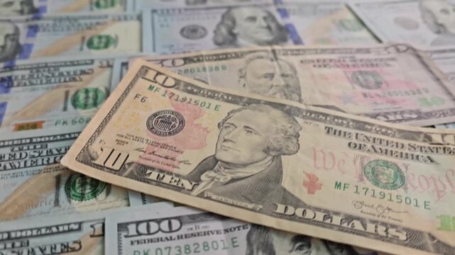 Money on a table shows different types of bills and banknotes from the United States of America in good light