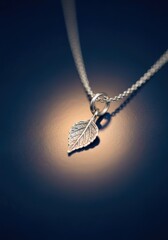 Fototapeta premium Delicate Silver Leaf Pendant Necklace on a Shimmering Background