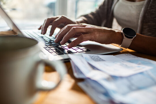 Person paying bills on laptop at home office