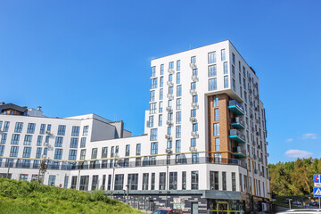 Obraz premium Modern White Apartment Complex with Blue Balconies