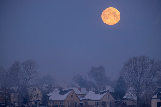 evening landscape with full moon in clear sky. Houses of Jelgava town, Latvia. Cold winter landscape
