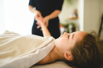 Professional masseur makes massage to a child girl