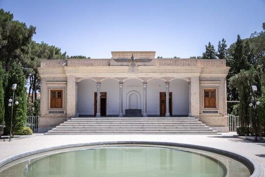 Yazd Atash Behram fire temple in Yazd, Iran, a Zoroastrian sacred site with Faravahar symbol above a columned facade and broad steps, reflected in a calm pool, symbolizing ancient spiritual heritage.