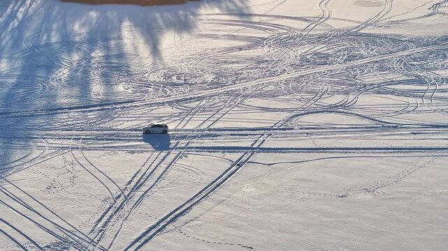Aerial winter ice rally carto pit Lake Sniardwy Poland 4K. Largest lake in Poland. Sport recreation below zero cold polar arctic temperature freezes water safe depth. Cars speed across solid ice.